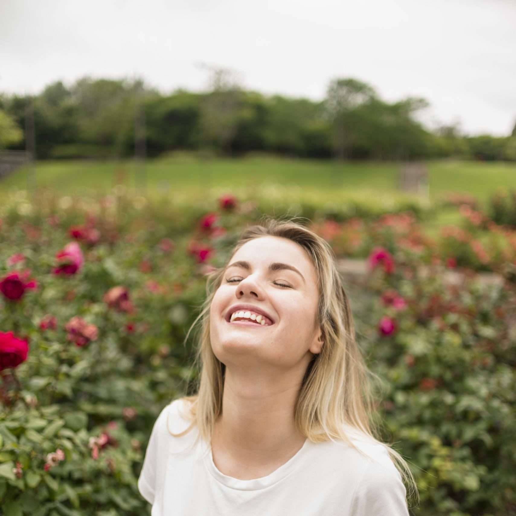 feliz-mulher-ficar-em-jardim-flor